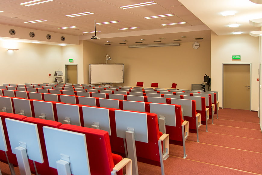 Empty University Lecture Hall with Red Chairs and Whiteboards