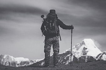 Hiker with Backpack Standing on Mountain Ridge