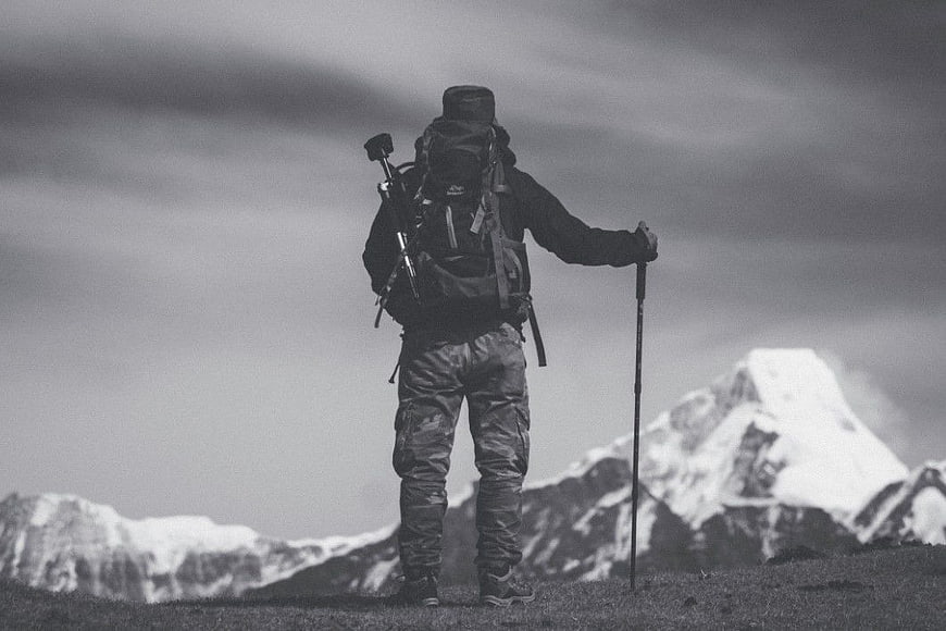 Hiker with Backpack Standing on Mountain Ridge