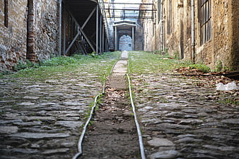 Abandoned cobblestone railway track in old industrial ruins
