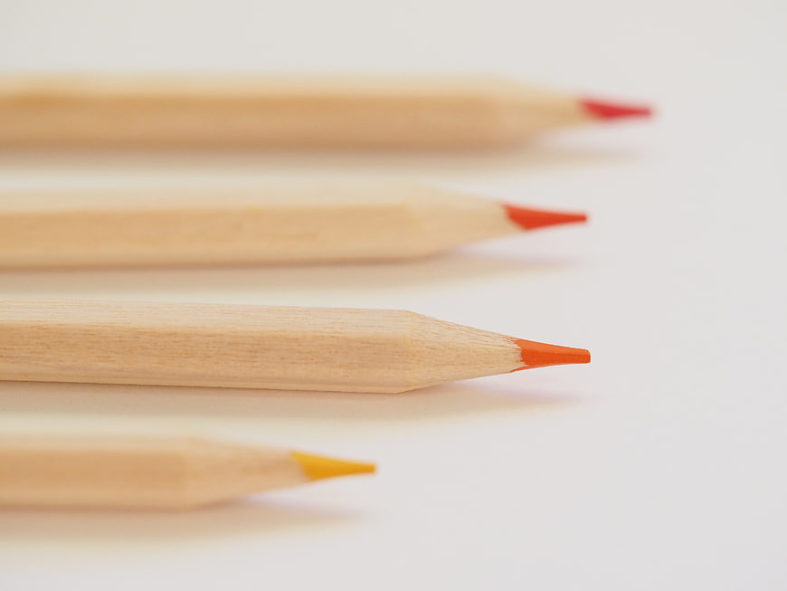 Close-up of wooden colored pencils on white background