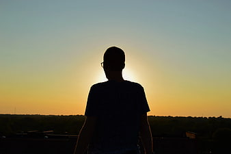 Silhouette of Man Watching Sunset from Rooftop