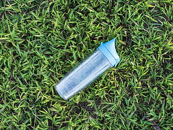 Blue Water Bottle Lying on Green Grass