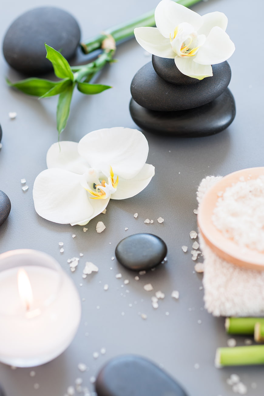 Spa stones, orchids, candle, and salt for relaxation