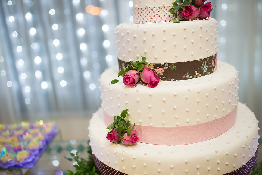Elegant Multi-Tier Wedding Cake with Pink Roses and Ribbons