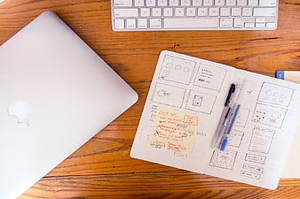 UX Design Workspace with Wireframe Sketches and MacBook