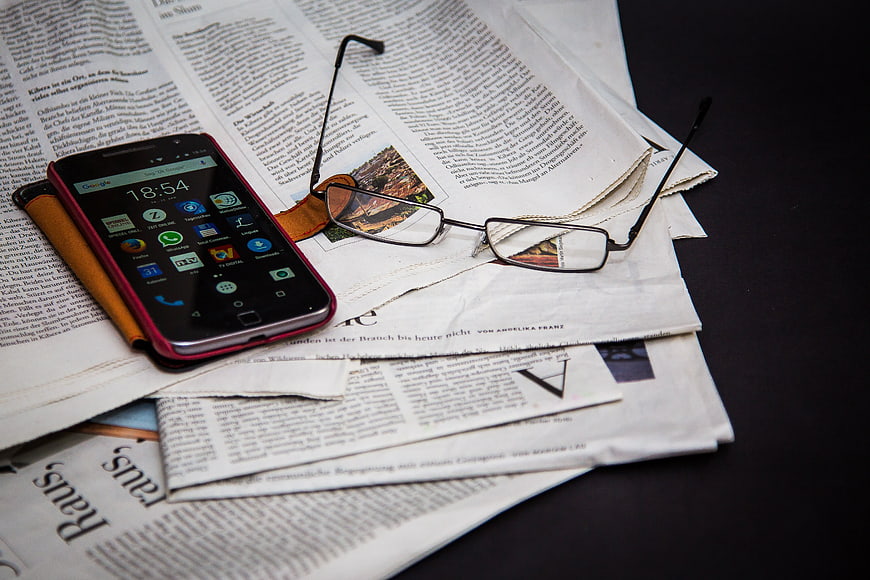Smartphone and Glasses on Newspaper