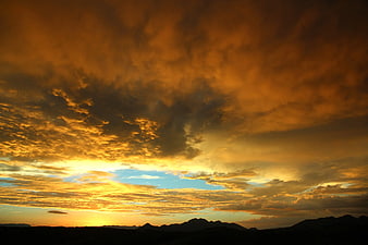 Dramatic Orange Sunset Sky Over Silhouette Mountains