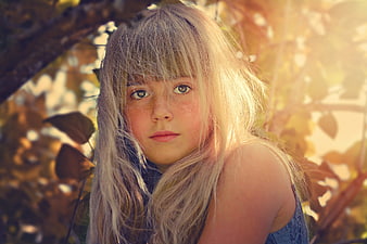 Portrait of a freckled blonde girl in autumn sunlight