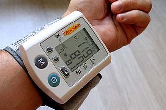Close-up of wrist blood pressure monitor displaying readings