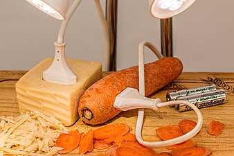 Carrot and cheese plugged into lamp with batteries