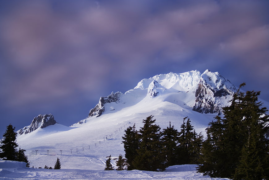 Snowy Mountain Peak with Ski Lifts and Pine Trees