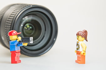 Lego photographer and model with camera lens on white background