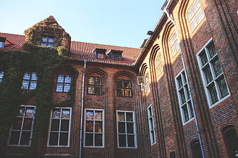 Historic red brick building with ivy and arched windows