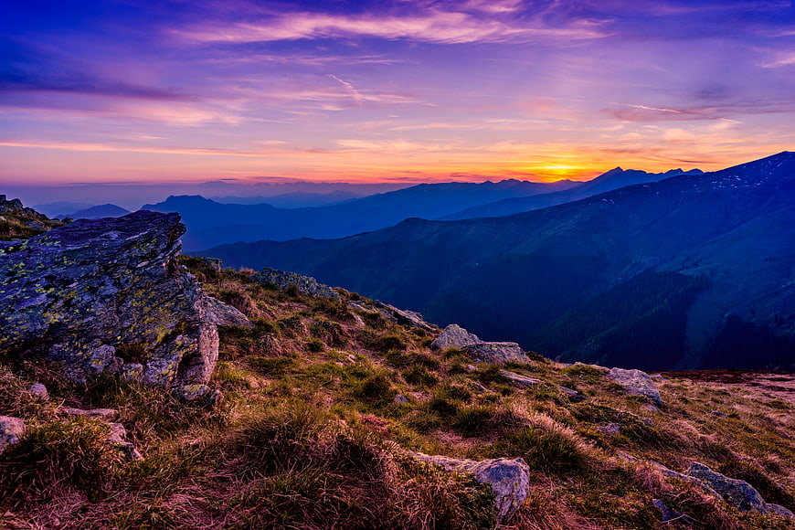 Dramatic Mountain Sunset with Purple Sky and Rocky Ridge