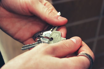 Close-up of hands holding silver house keys