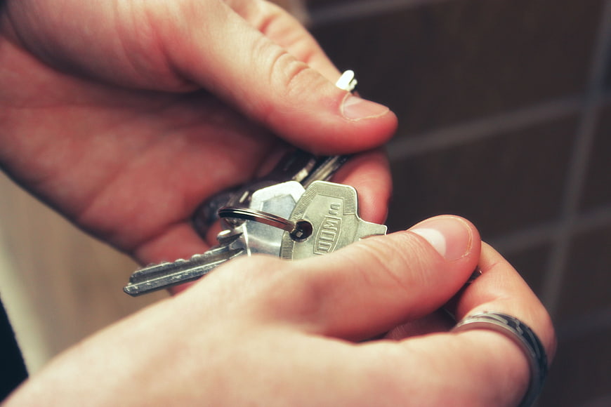 Close-up of hands holding silver house keys