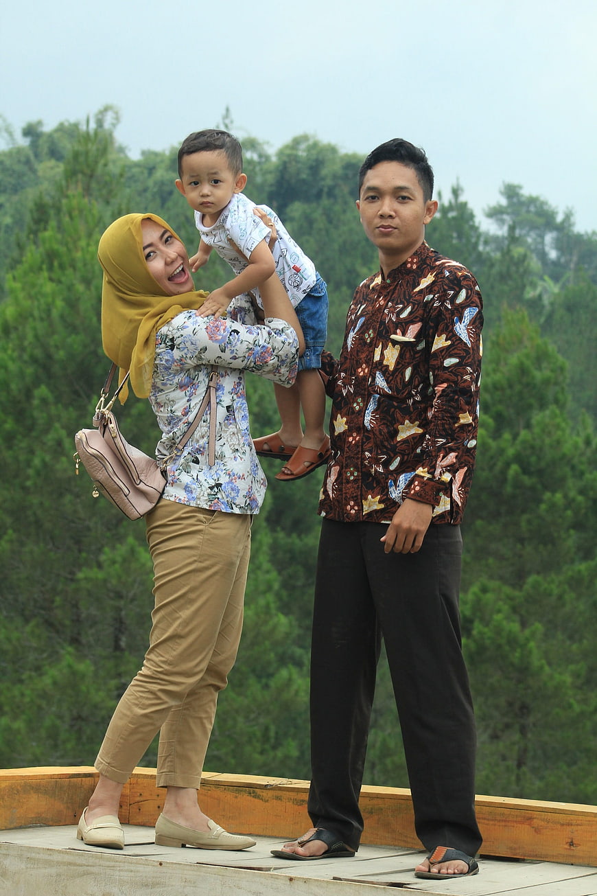 Happy Asian Family Portrait on Wooden Deck with Forest Background