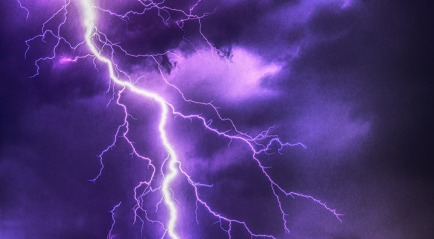 Dramatic Purple Lightning Strike in Dark Stormy Clouds