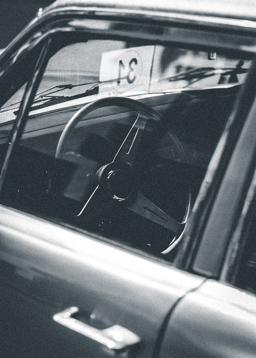 Vintage car interior with steering wheel and racing number