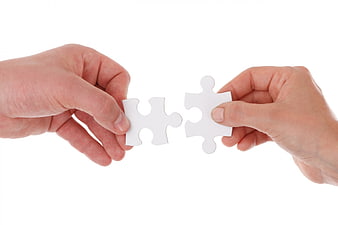 Two Hands Connecting White Puzzle Pieces on White Background