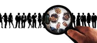 Magnifying glass focusing on diverse business team silhouettes