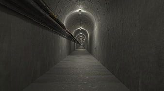 Dark concrete tunnel with pipes and overhead lights