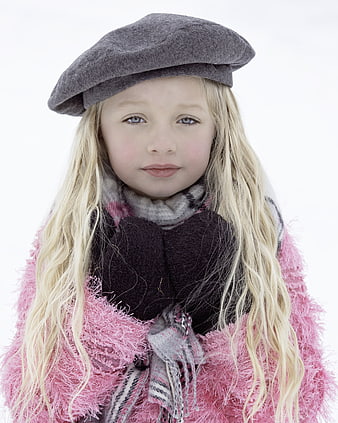 Portrait of a young blonde girl wearing a gray beret and pink sweater