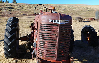 Vintage Rusty Farmall Tractor in Dry Field