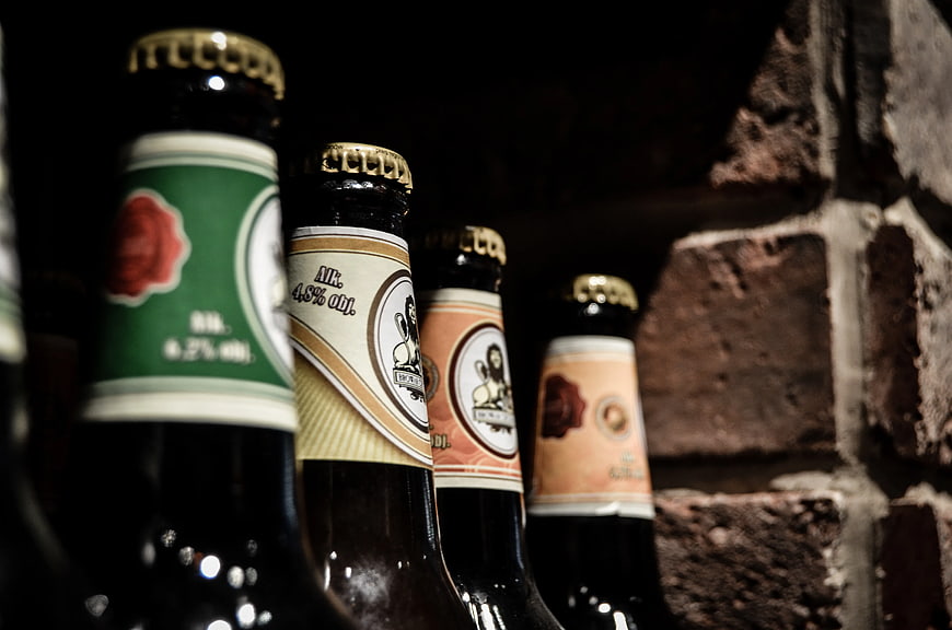 Craft Beer Bottles Lined Up Against Brick Wall
