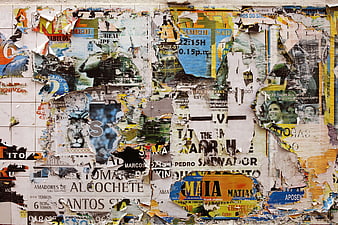 Textured wall covered in torn posters and flyers