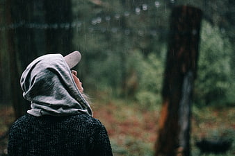 Woman in Hoodie Looking Up in Rainy Forest