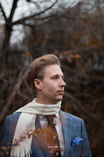 Handsome man in blue plaid suit and white scarf outdoors