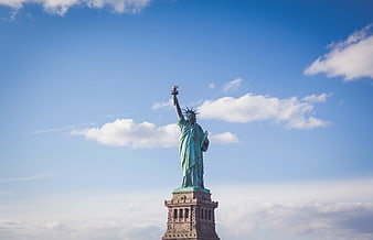 Statue of Liberty against blue sky with clouds