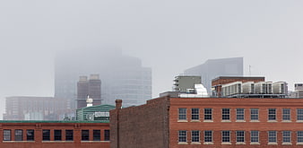 Foggy urban skyline with brick buildings and misty skyscrapers