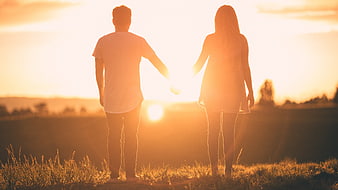 Couple Holding Hands Silhouette at Sunset in Field