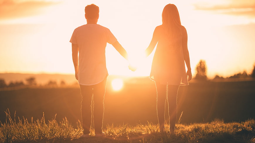 Couple Holding Hands Silhouette at Sunset in Field
