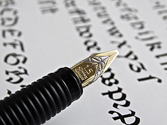 Close-up of Gold Fountain Pen Nib on Calligraphy Paper