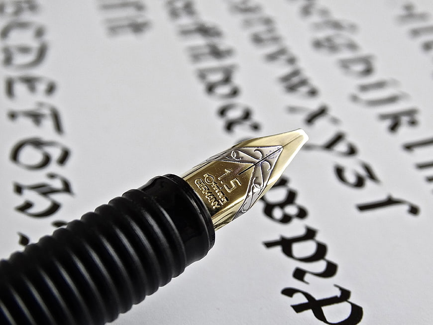 Close-up of Gold Fountain Pen Nib on Calligraphy Paper