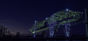 Illuminated industrial conveyor bridge at night in Duisburg