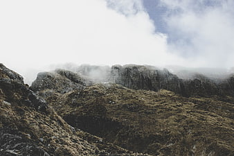 Misty Mountain Ridge with Foggy Clouds and Rocky Terrain