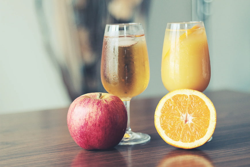 Fresh fruit juice and apple on wooden table