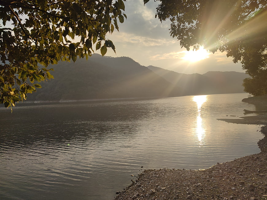Serene Lake Sunset with Sun Rays Through Trees