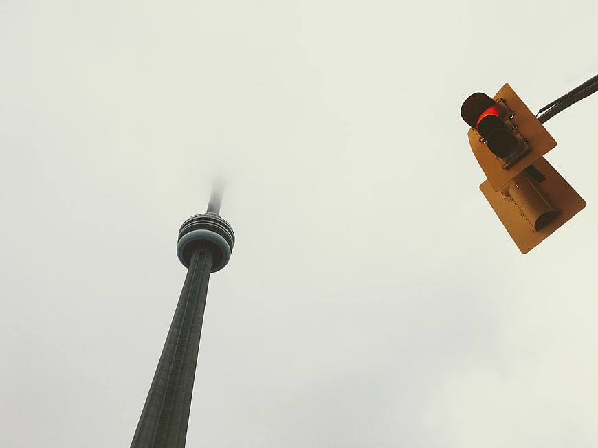 CN Tower and Traffic Light Against Overcast Sky