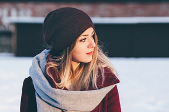 Young Woman in Winter Scarf and Beanie in Snow