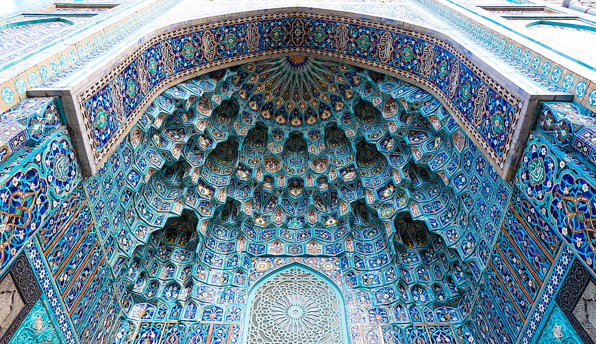 Intricate Blue Tilework And Muqarnas Vaulting In Islamic Mosque Architecture