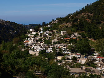 Hillside village in Crete with white houses and green mountains