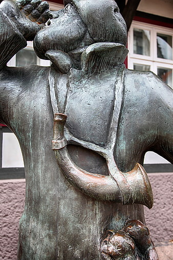 Close-up of bronze night watchman statue with horn