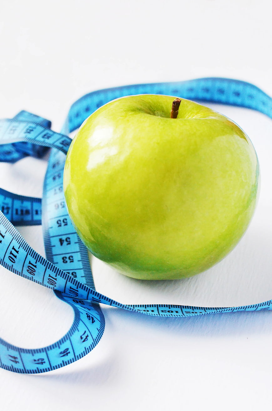 Green Apple with Blue Measuring Tape on White Background