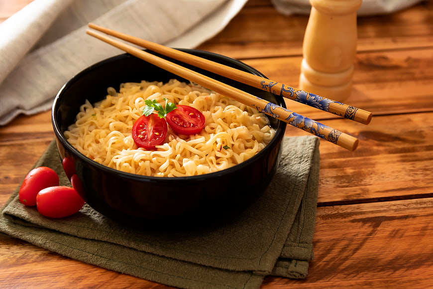 Bowl of Asian Noodles with Tomatoes and Chopsticks